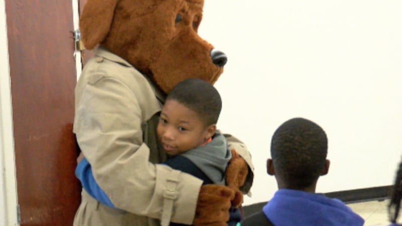 McGruff (The Crime Dog) hugs a student at Hawkins Elementary School during a Halloween safety...